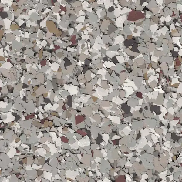 A close-up view of a floor surface with a decorative epoxy coating featuring scattered multicolored flakes in muted earth tones.
